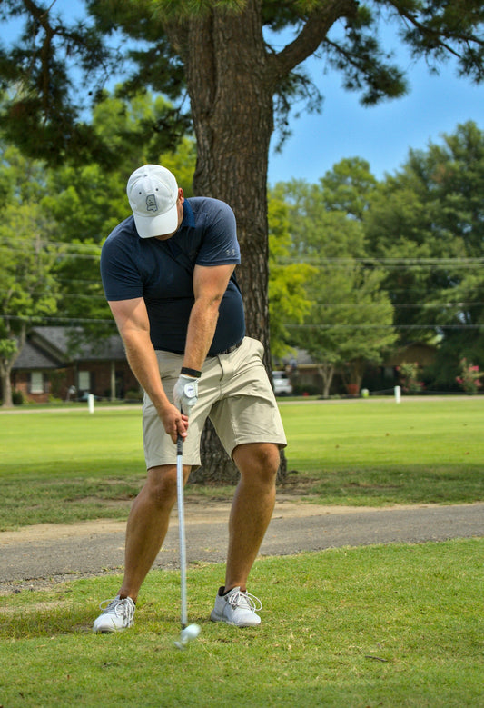 man in black t-shirt and white shorts playing golf during daytime