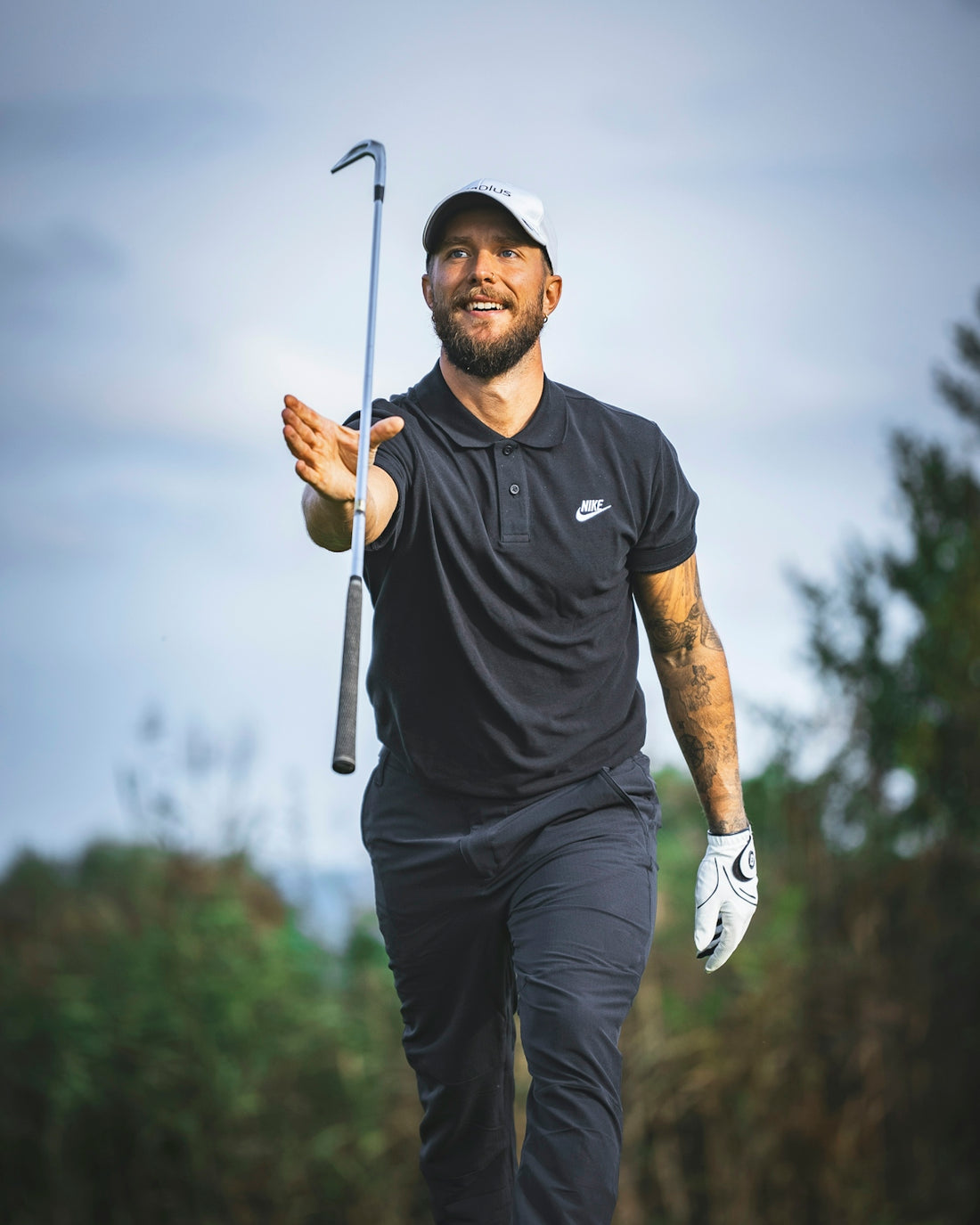 a man holding a golf club and a golf ball