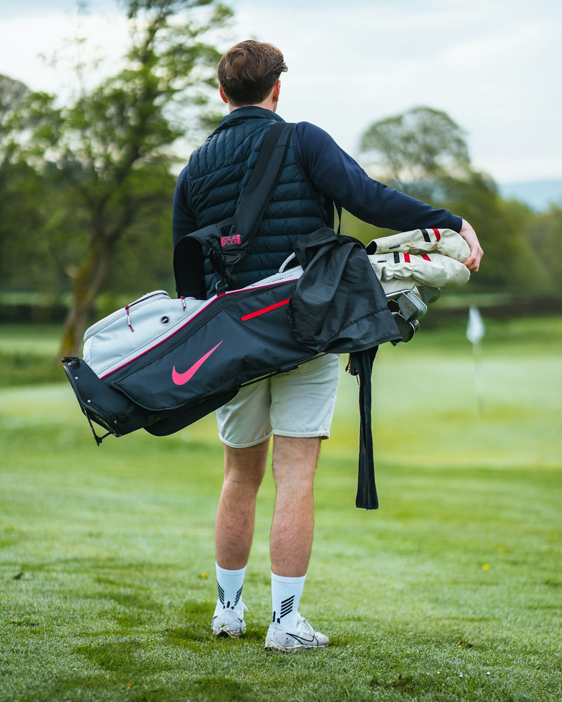 a man carrying a golf bag on a golf course