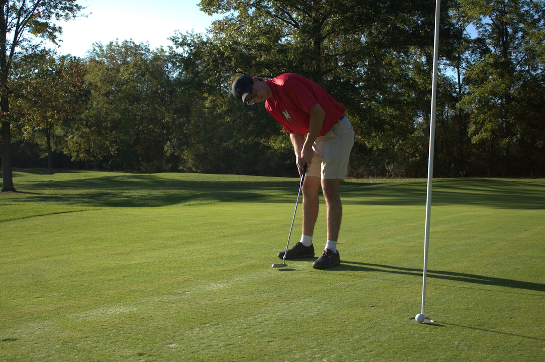 A man putting a putt on a golf course