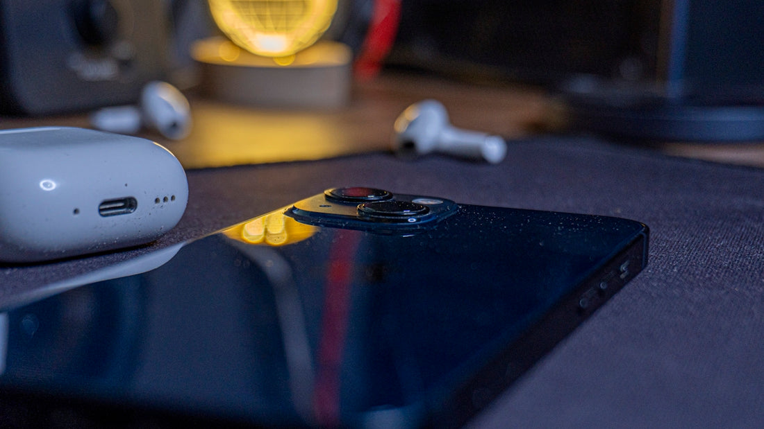 Smartphone, earbuds, and charging case arranged on a surface.