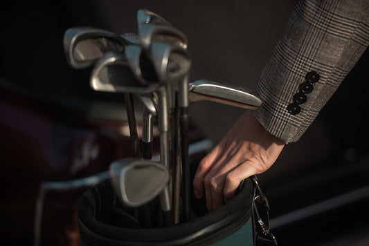 A man reaches for golf clubs.