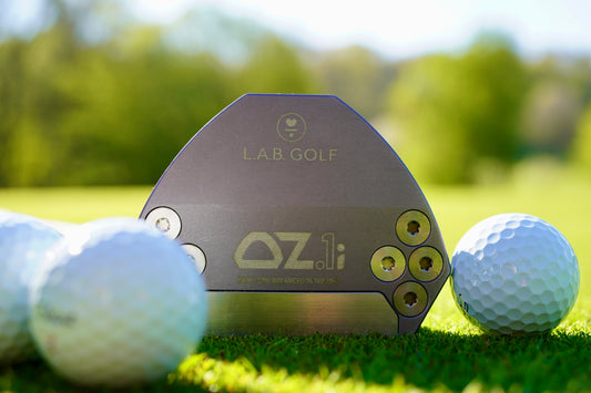 Golf putter and balls on a green course.